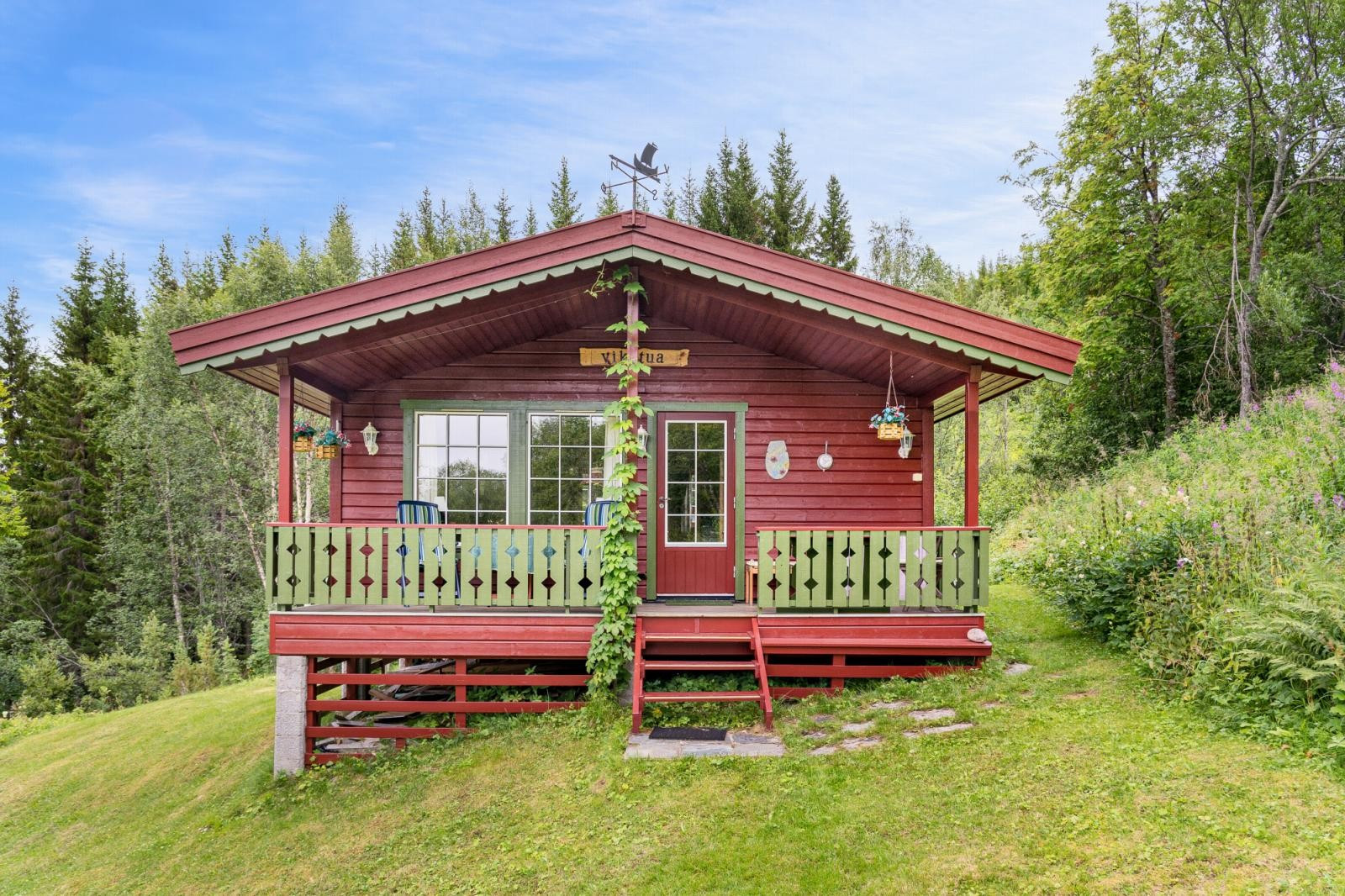 Hytta ligger på oversiden av veien.