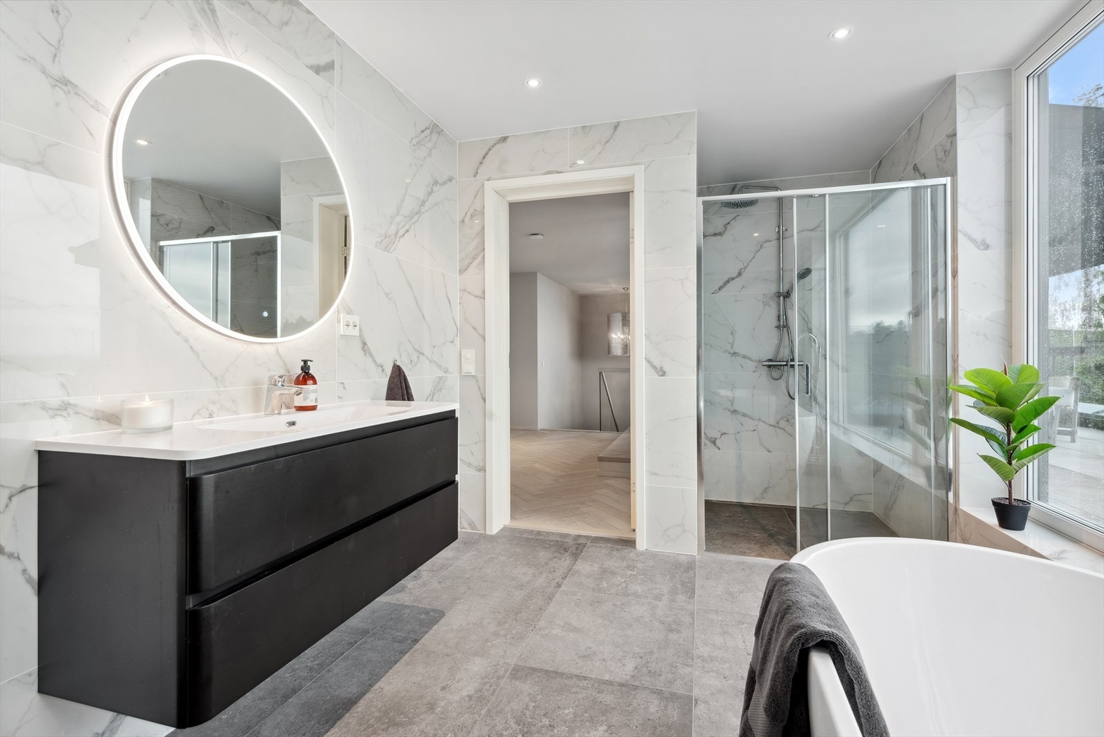 Badet er innredet med en baderomsinnredning i glatt utførelse med heldekkende servant og speil. Galleribilde