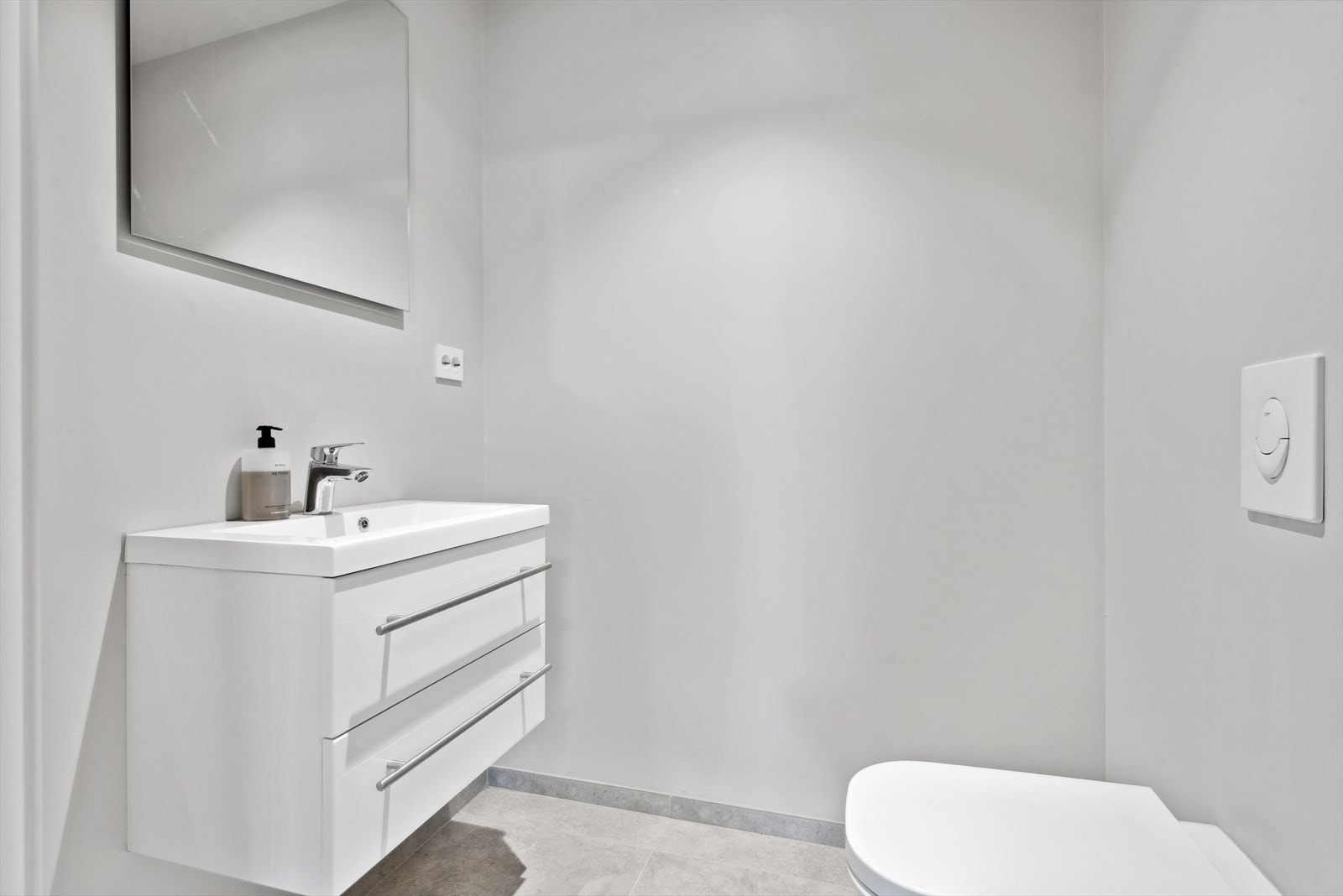 Wc u. etasje: Toalettrommet er utstyrt med en innredning med heldekkende servant, speil og et veggmontert toalett. Galleribilde