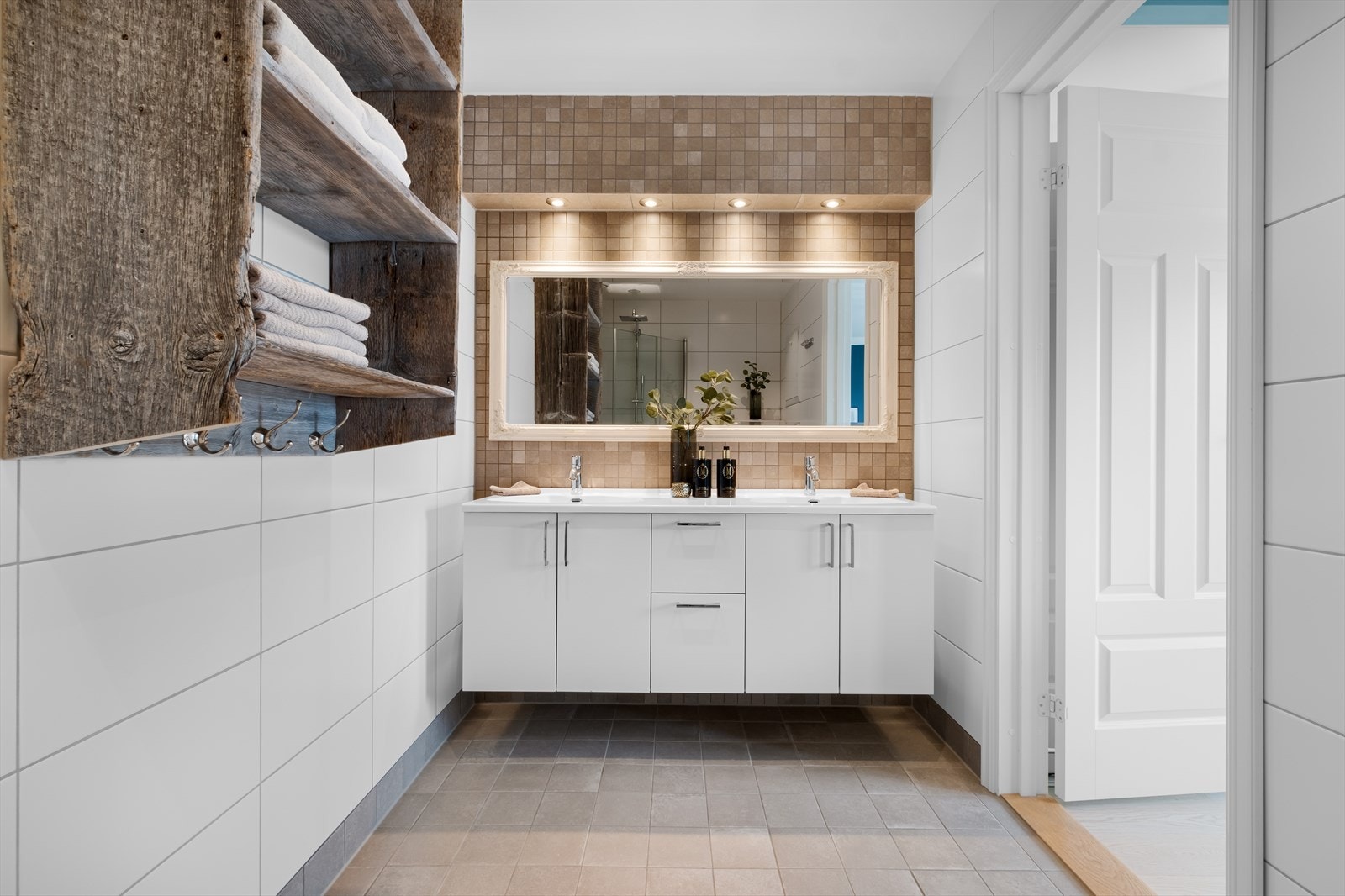 Videre har badet 2 servanter i innredning, speil, samt downlights over servantinnredning og i himling. Hyllen på badet er designet og laget hos Drivved. Galleribilde