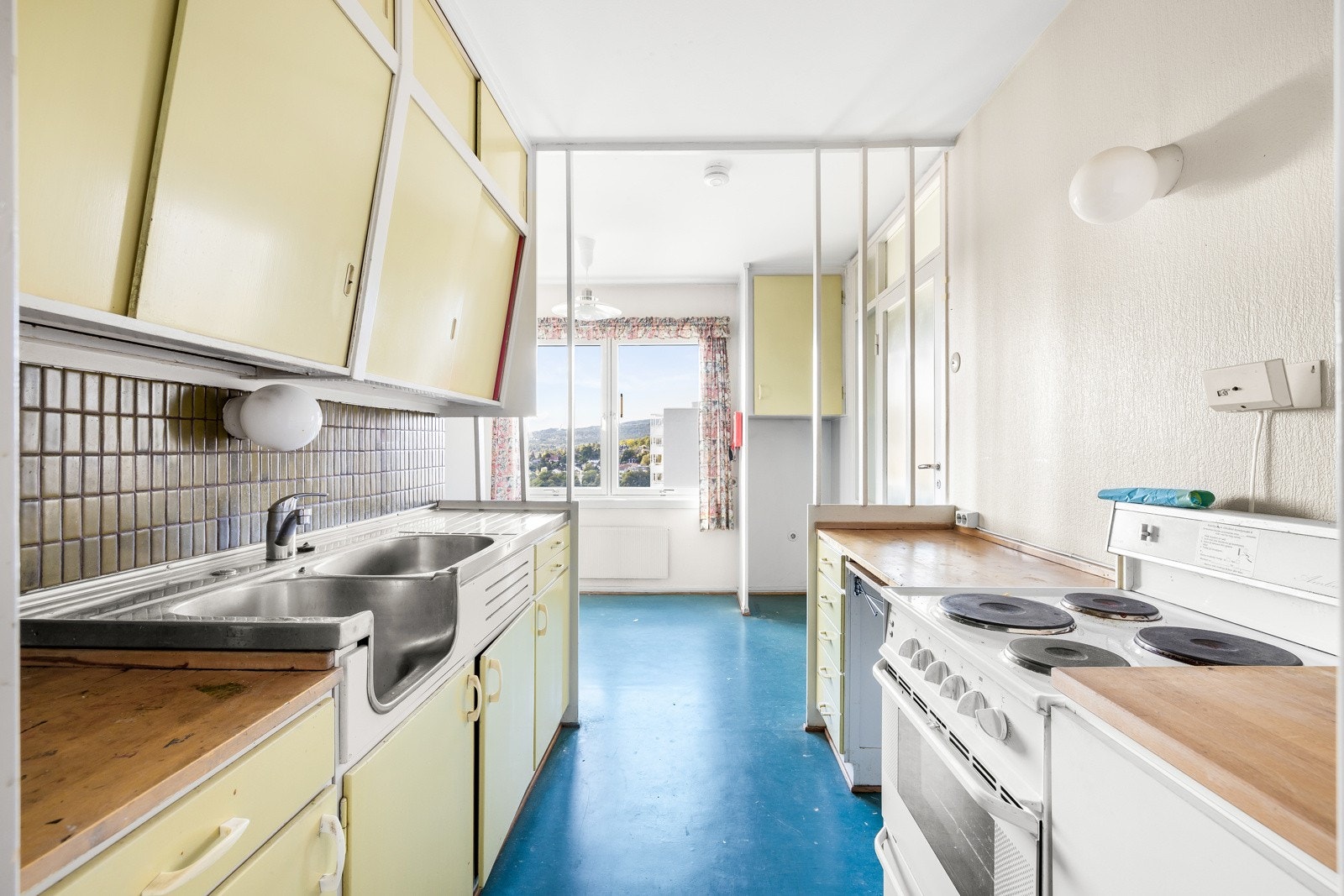 Malt tapet og fliser er belagt mellom kjøkkenbenk og overskap. Galleribilde