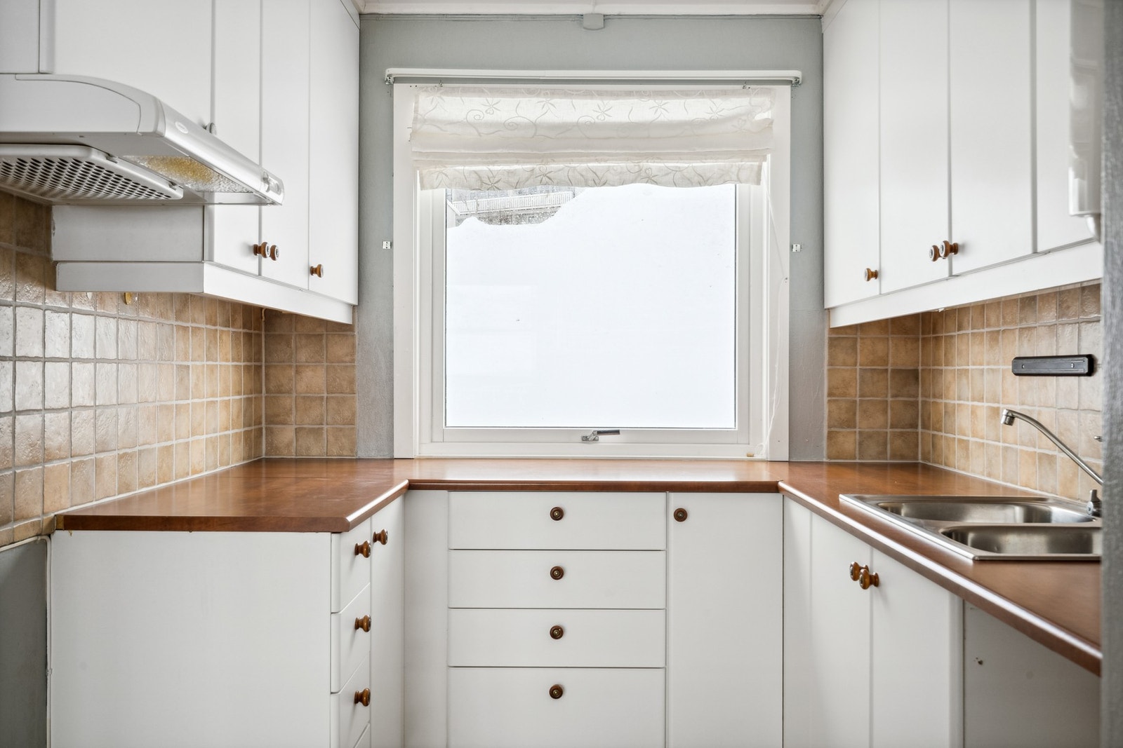Kjøkkeninnredning med hvite glatte fronter og laminat benkeplate. Galleribilde