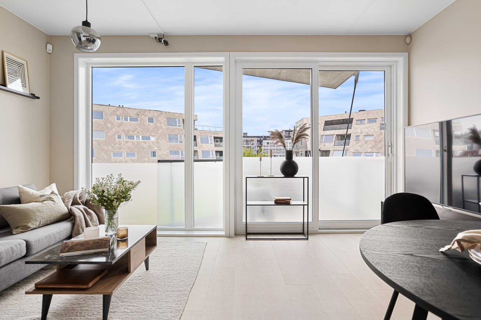 Åpen og fin stue med store vindusflater som slipper inn godt med dagslys