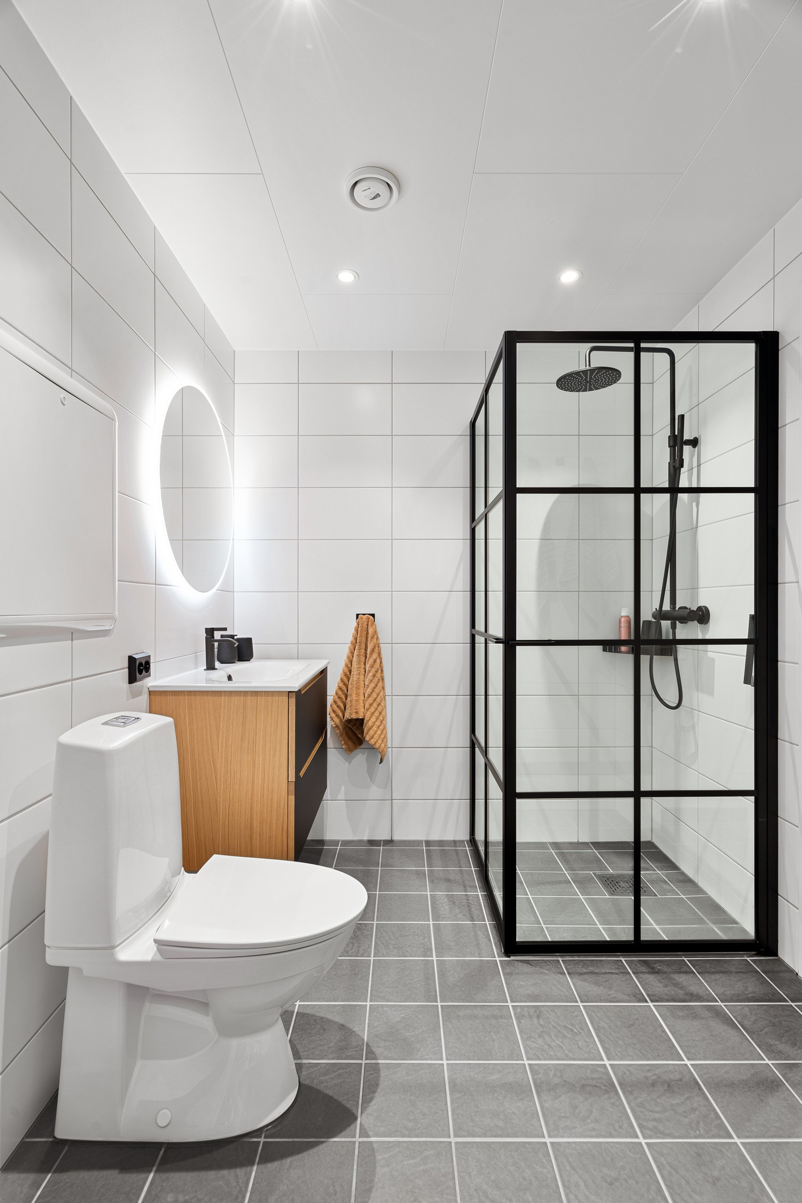 Badet er komplett flislagt og fremstår romslig.
