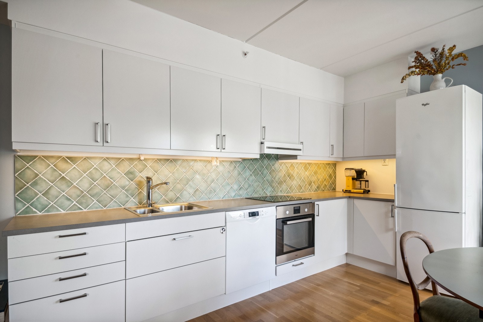 Det er mosaikkfliser som sprutbeskytter og under overskapene er det downlights Galleribilde