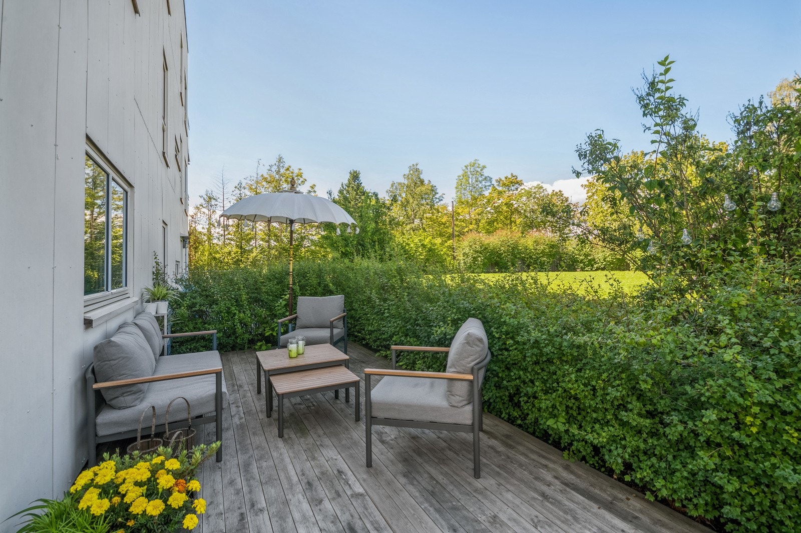 Markterrassen ligger skjermet til og er pent innrammet av hekk Galleribilde