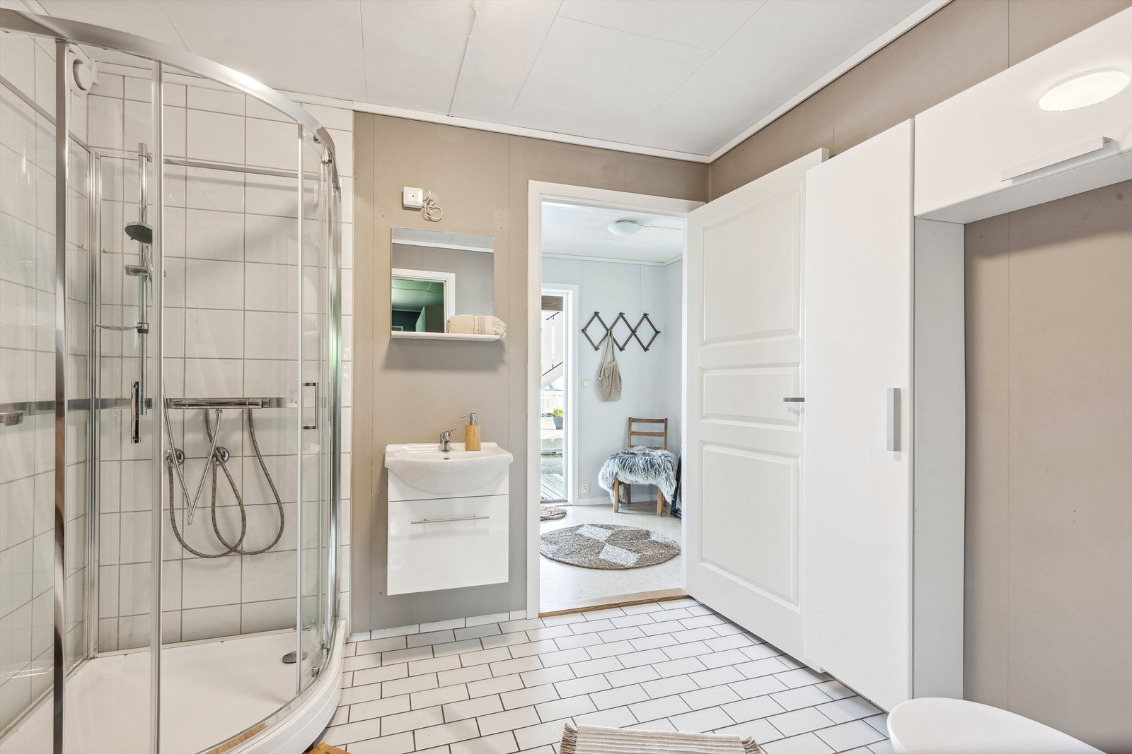 Baderom med fliser på gulvet og malte plater/fliser på veggene. Galleribilde