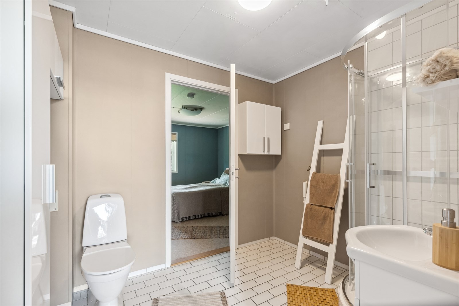 Rommet har innredning med nedfelt servant, veggskap, toalett, dusjkabinett og opplegg for vaskemaskin. Galleribilde