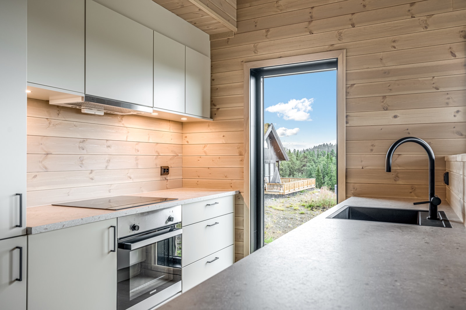 Kjøkken - Flott Strai kjøkken i moderne farge og stil, øy med vask og oppvaskmaskin og godt med plass, skjult fra spisestue Galleribilde