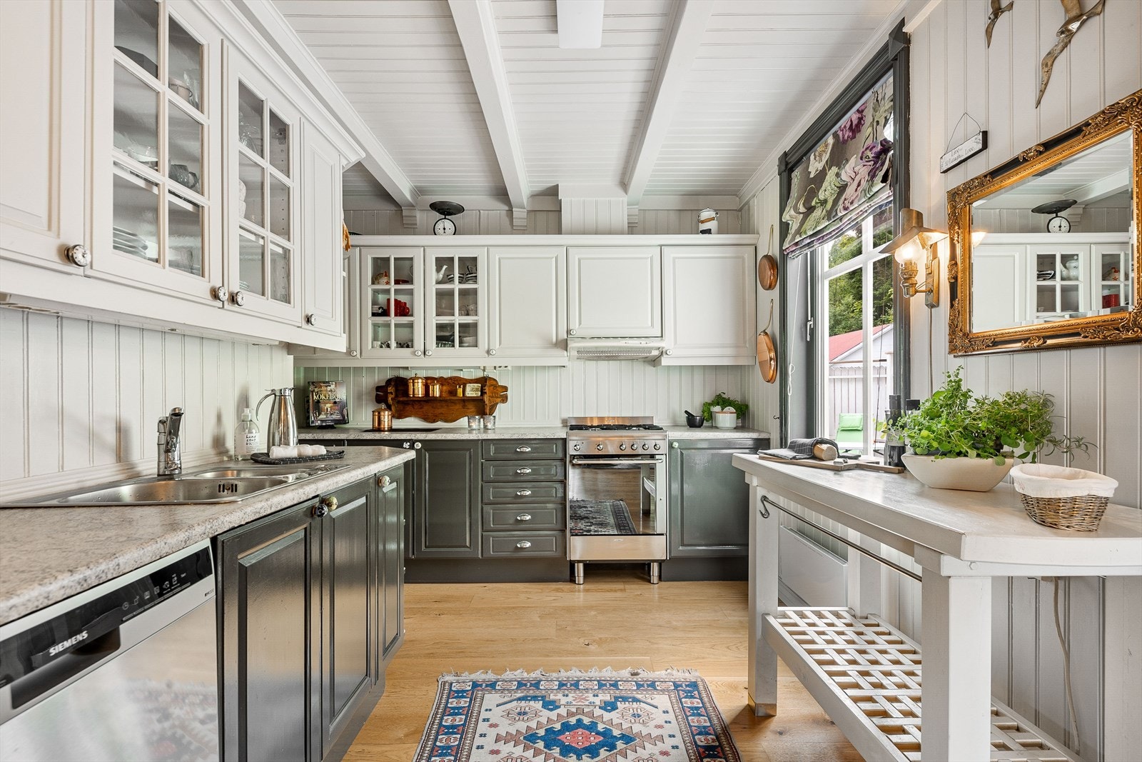 Det er godt med oppbevaringsplass i innredning. Et flott kjøkken med god arbeidsplass på benkeplater Galleribilde