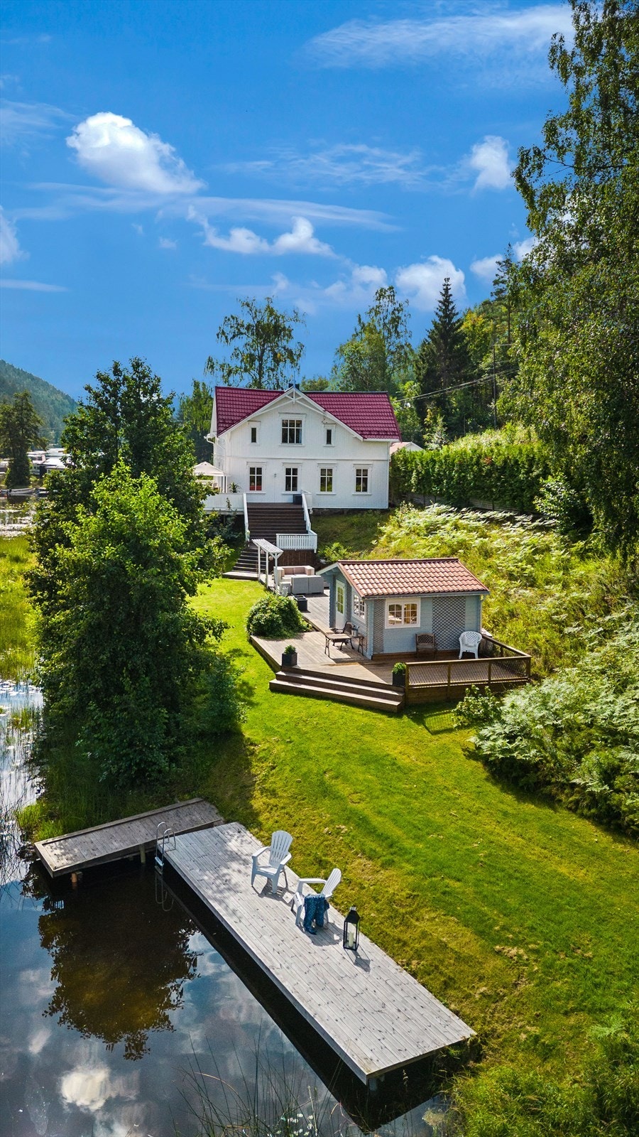 Stort plenareal med god plass til aktiviteter som strekker seg langs tomtegrense mot vannet og ned til det hyggelige bryggeanlegget Galleribilde
