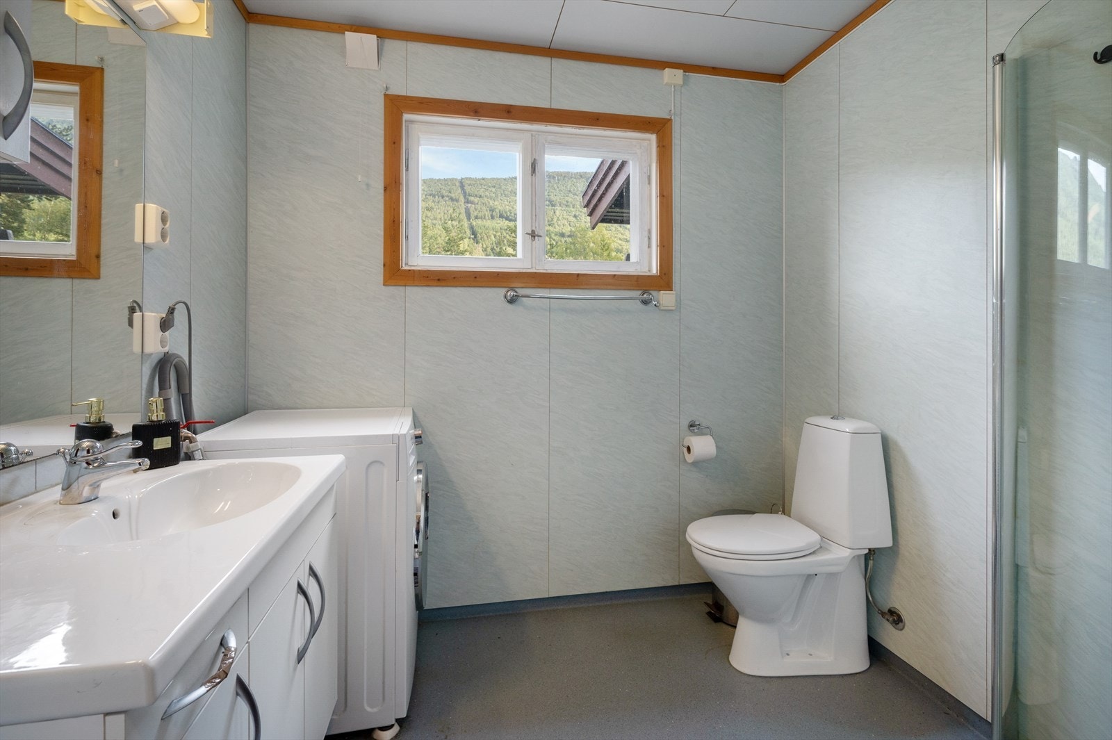 Badet i 1. etasje består av vinyl gulvbelegg, baderomsplater på vegger og folierte plater i himling. Det er varmekabler i gulv. Galleribilde