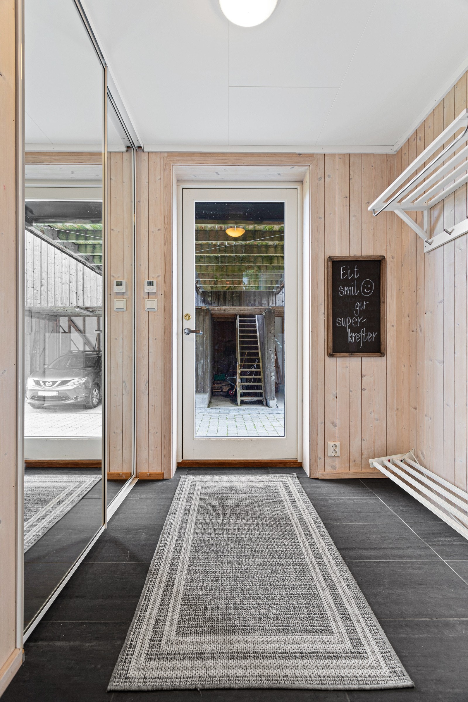 Innbydende entré med praktisk innfelt skyvedørsgarderobe. Flislagt gulv med gulvvarme gir en behagelig velkomst. Galleribilde