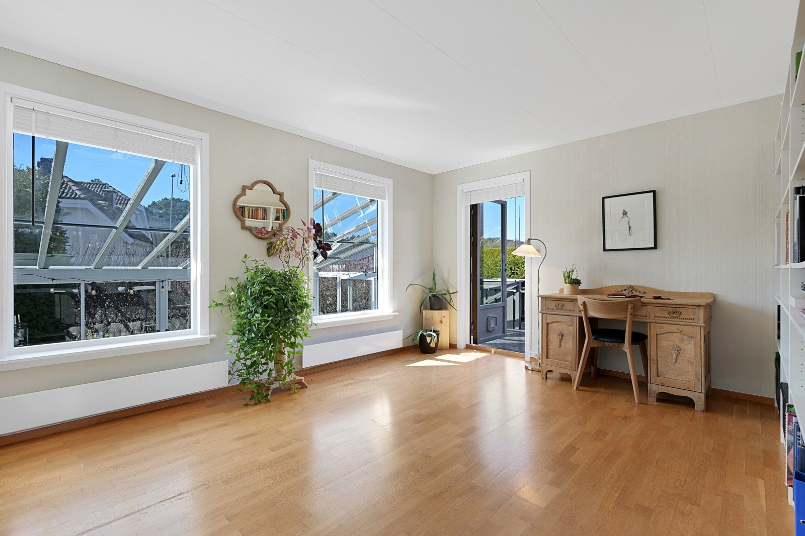 Stue og spisestue med peisovn samt utgang til hagen og innglasset terrasse. Galleribilde
