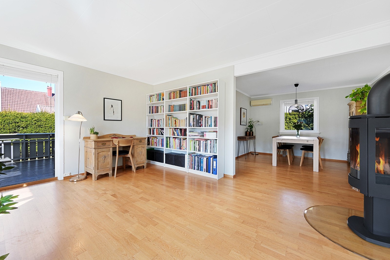 Stue og spisestue med peisovn samt utgang til hagen og innglasset terrasse. Galleribilde