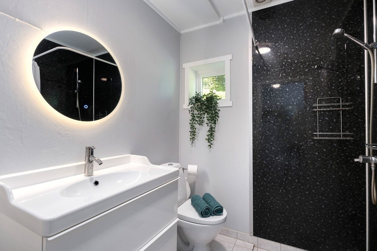 Badet i 1. etasje veldig moderne med en baderomsinnredning med nedfelt servant med skuffeløsning under. Dette er nylig skiftet og er fra 2023. Gulvet er flislagt med elektriske varmekabler. Galleribilde