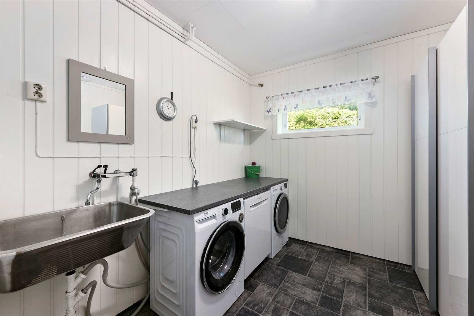 I tillegg til god plass for vaskemaskin og tørketrommel på badet er det gjort plass til et stort dobbelt garderobeskap her. Det er også utslagsvask/servant på vaskerommet. På gulvet har du vinylbelegg med elektriske varmekabler under. Galleribilde