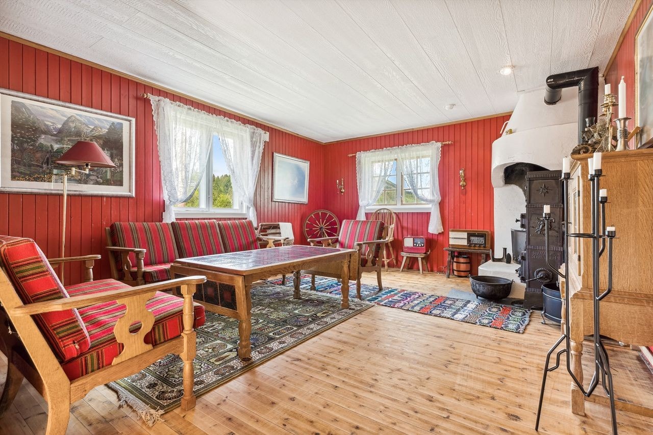 Opp en liten trapp kommer man til den andre stuedelen. Her er det rødmalt panel på veggene og furugulv. Galleribilde
