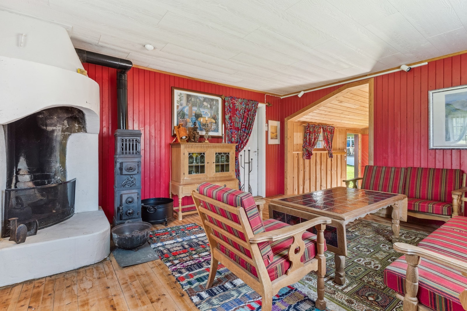 Rommet er romslig, og vinduene slipper høstsolen flott inn. Her er det etablert en åpen peisovn og en gammel etasjevedovn som varmekilder. Galleribilde