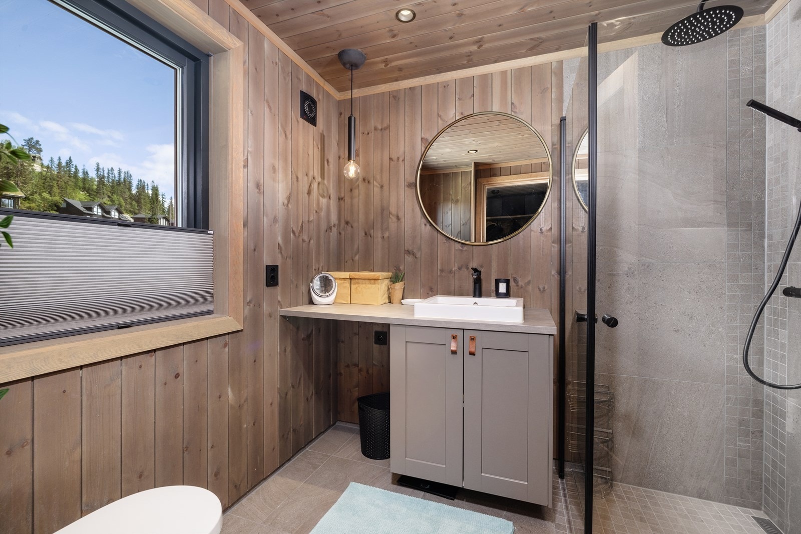 Badet har fliser m/varmekabler på gulv, fliser i dusjsone og trepanel i tak og på vegger. Galleribilde