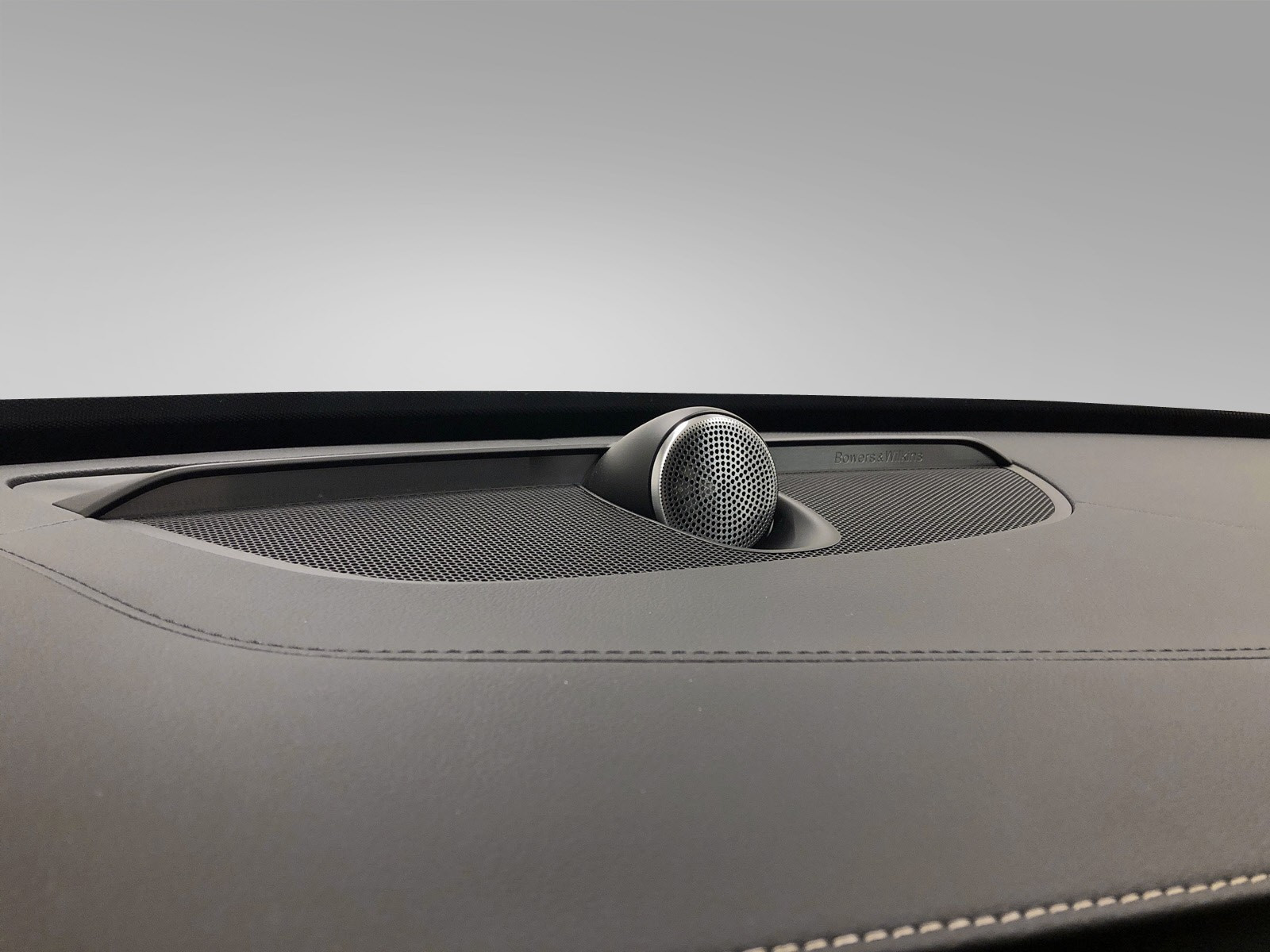 Bowers & Wilkins senter høyttaler pent plassert på skinntrykket dashboardet