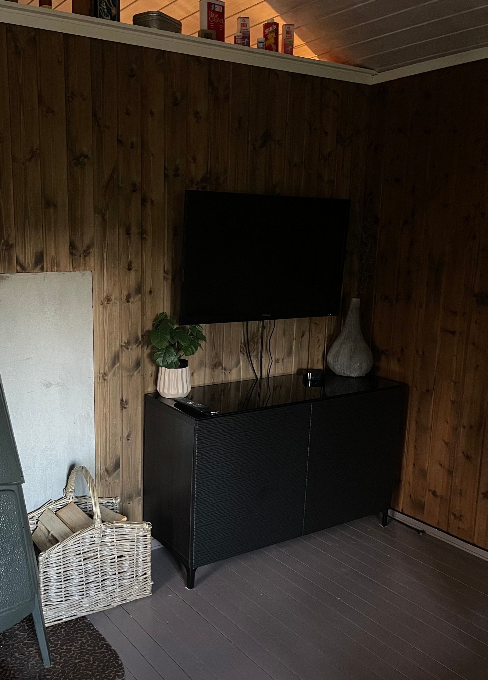 Tv med Apple-tv. Noen brettspill finnes i skapet under tvn. Galleribilde