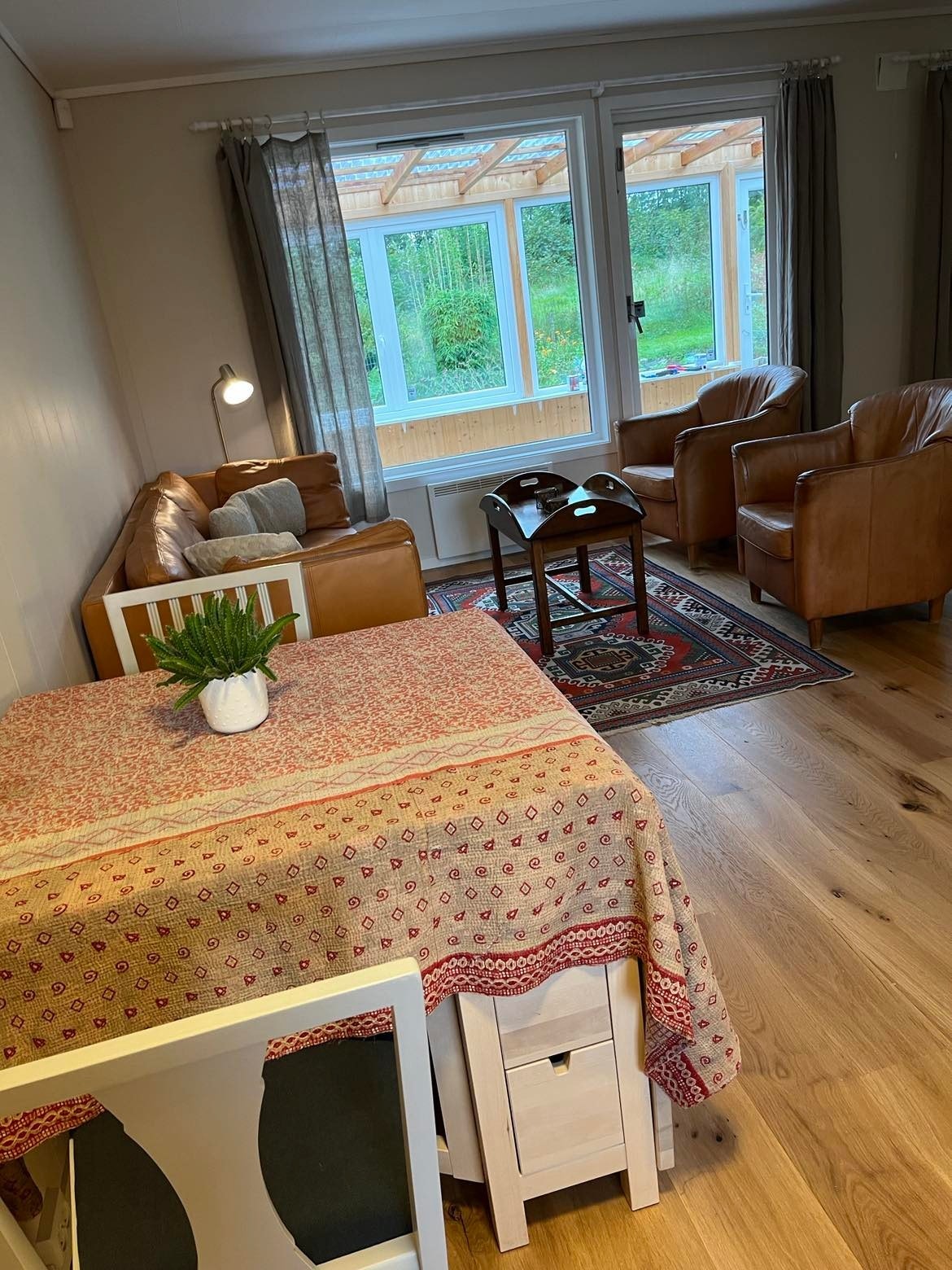 Kjøkkenbord og sofakrok med utsikt til vinterhage. Galleribilde