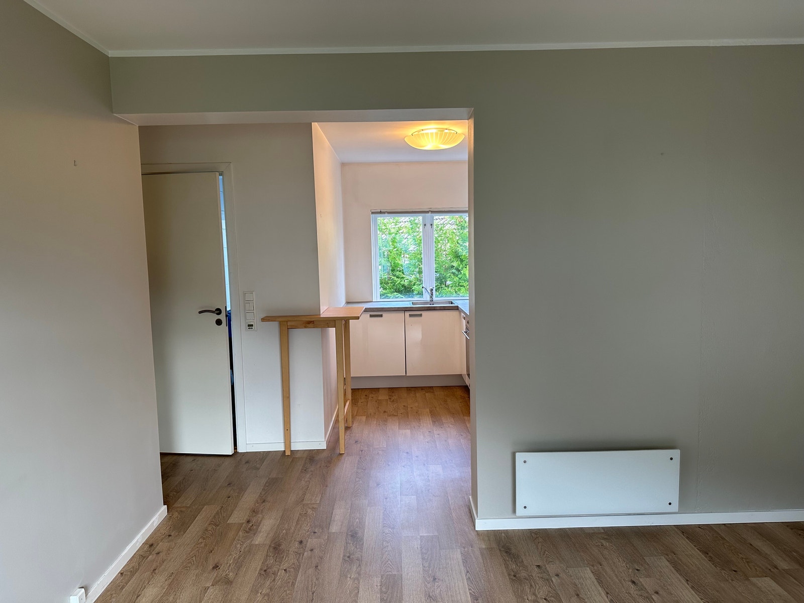 Stue/kjøkken på 22 kvadratt. Panelovn på vegg. Galleribilde