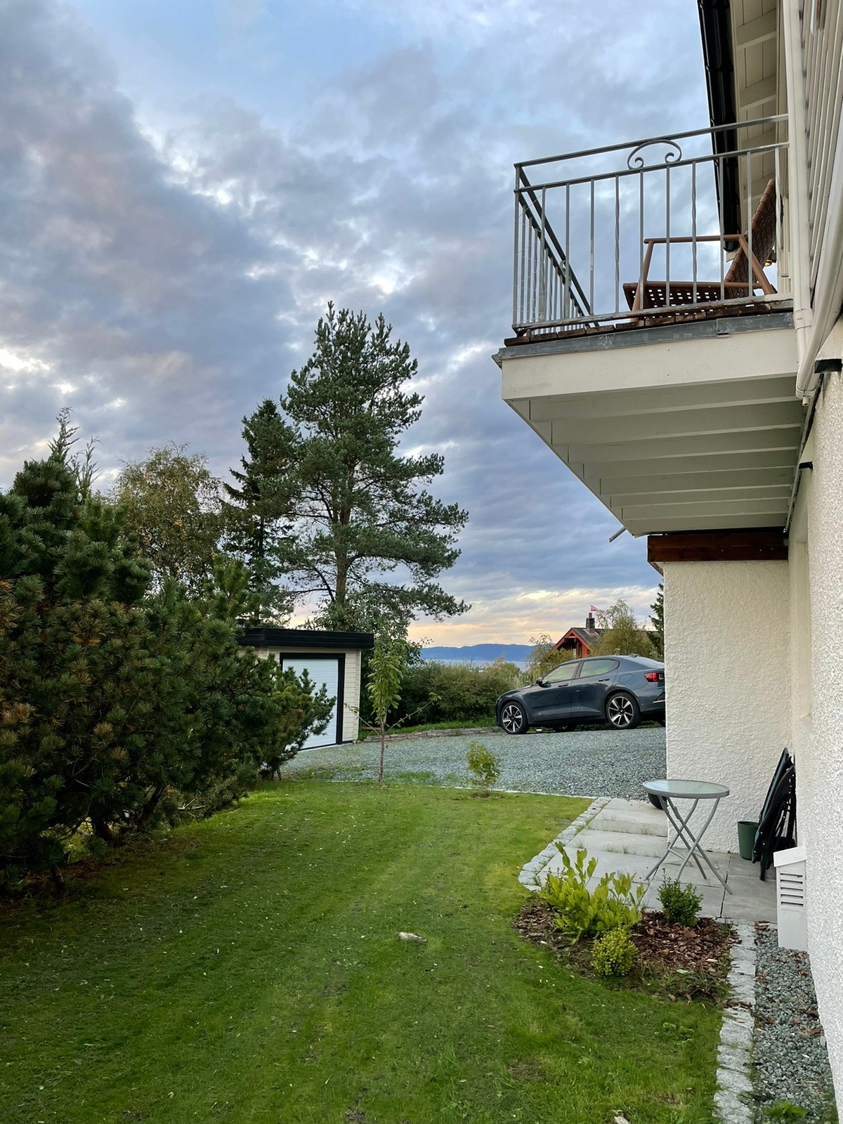 Utsikt til sjøen fra uteplassen, bildet viser også parkeringsplass Galleribilde