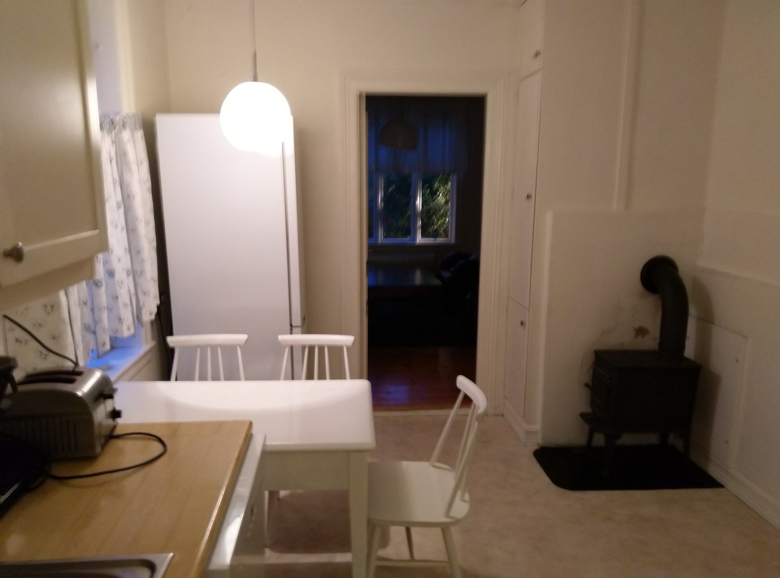 Kjøken i fyrste etasje, sett mot stova; spiseplass og vedovn med godkjent brannmut Galleribilde