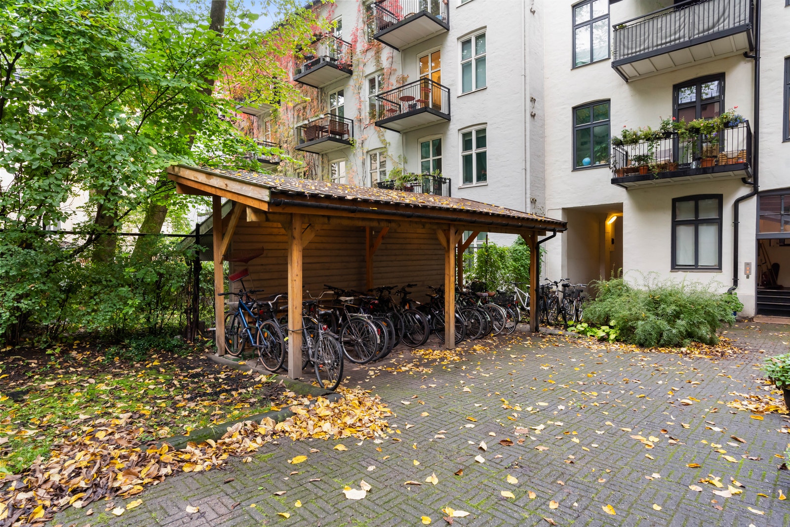 Flott og fin sykkeparkering i bakgården. Her står sykkelen trygt parkert under tak. Galleribilde