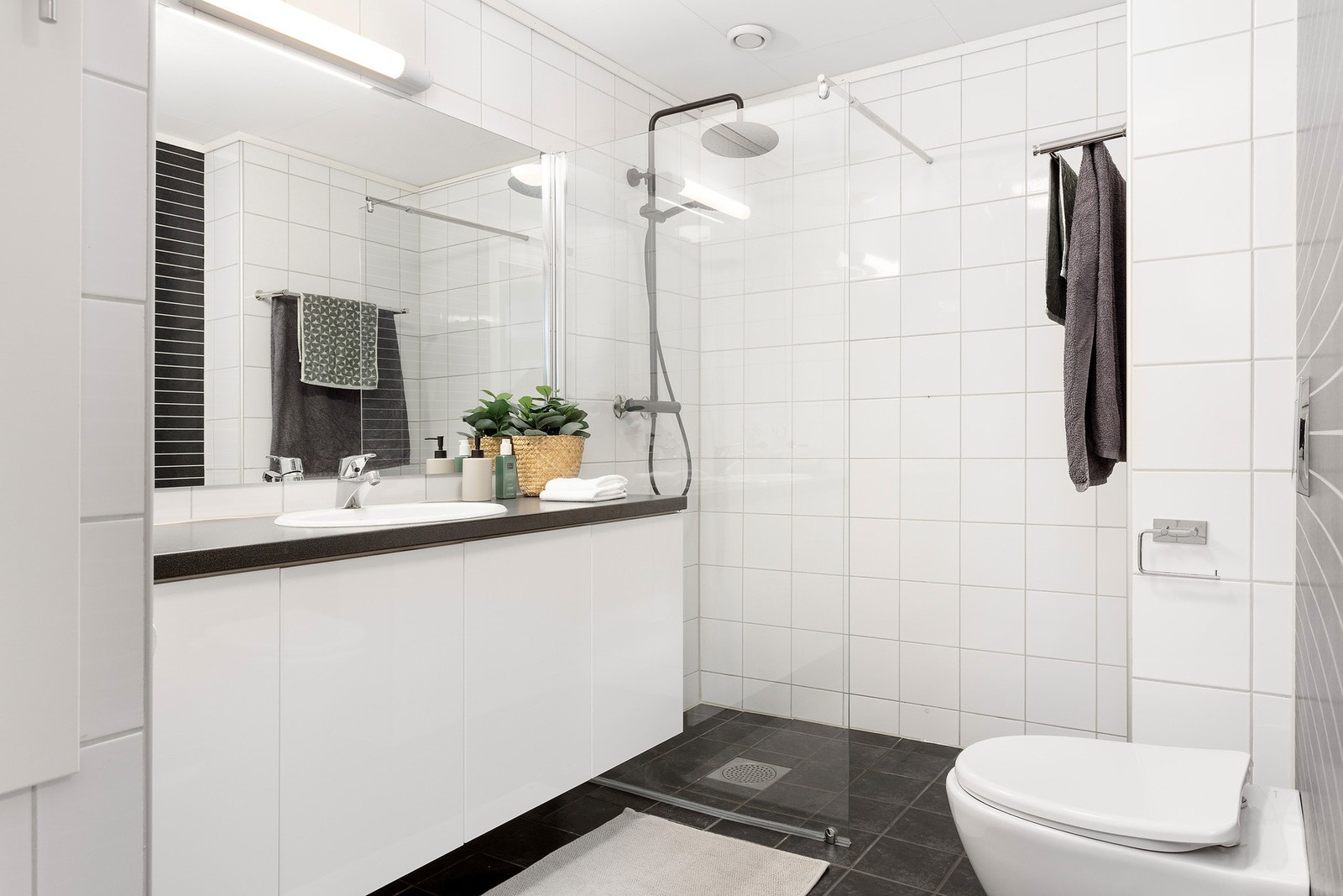 Pent og romslig bad fra 2009 med dusj, varmekabler i gulv, servant i skap og vegghengt wc. Galleribilde