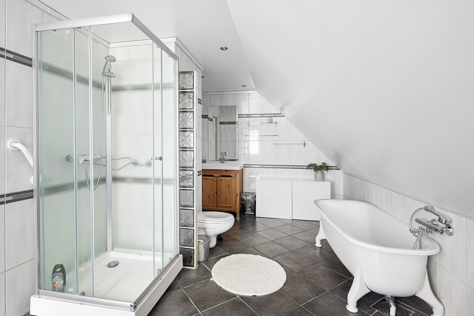 Badet er praktisk innredet med dusjkabinett, badekar og servantskap med porselensvask. Galleribilde