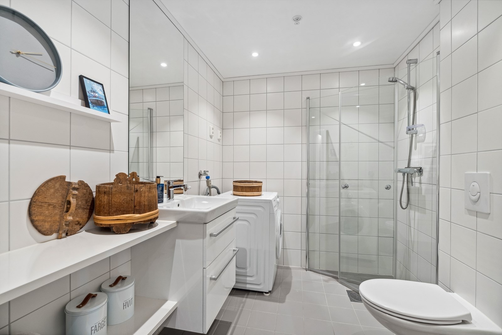 Bad 1 fremstår som lyst og innbydende og inneholder servant, speil, dusjhjørne, vegghengt toalett og opplegg for vaskemaskin. Galleribilde