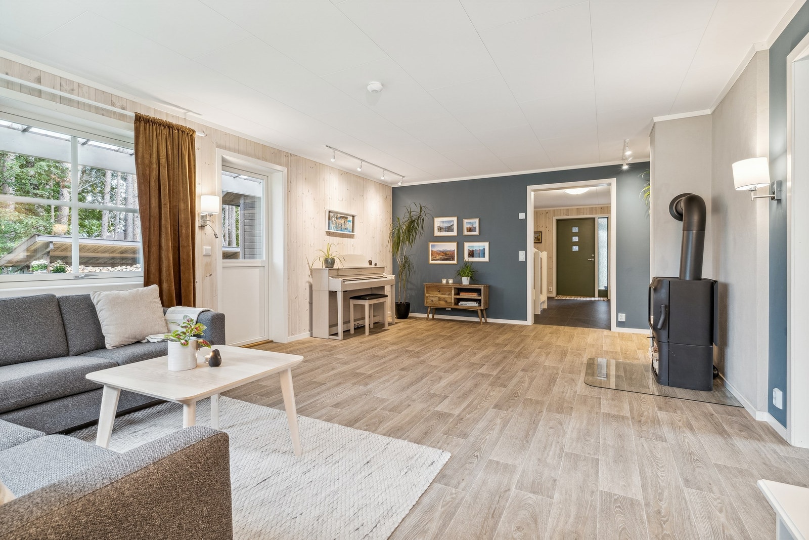 Stua er innredet med en kombinasjon av trepanel og malte plater Galleribilde