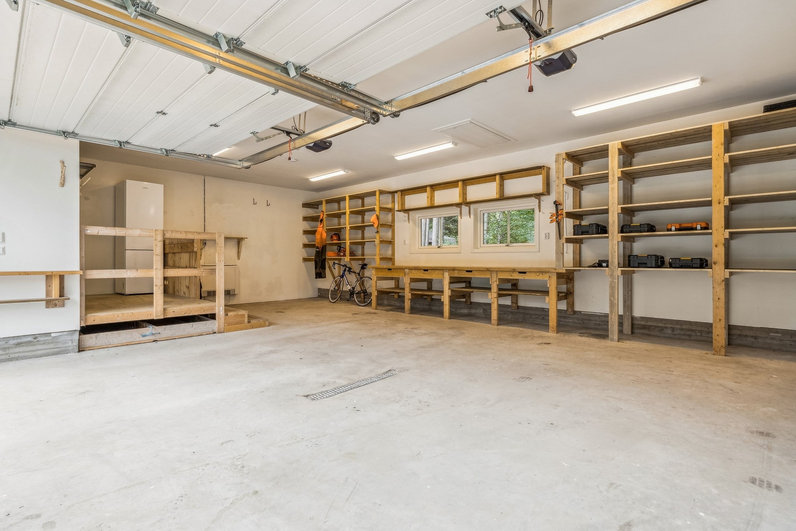...som har plass til både biler, verktøy og hobbyutstyr. Praktisk dør inn fra inngangsplattingen. Under trappa er det laget løsning for oppbevaring av vinter- og eller sommerhjul. Galleribilde
