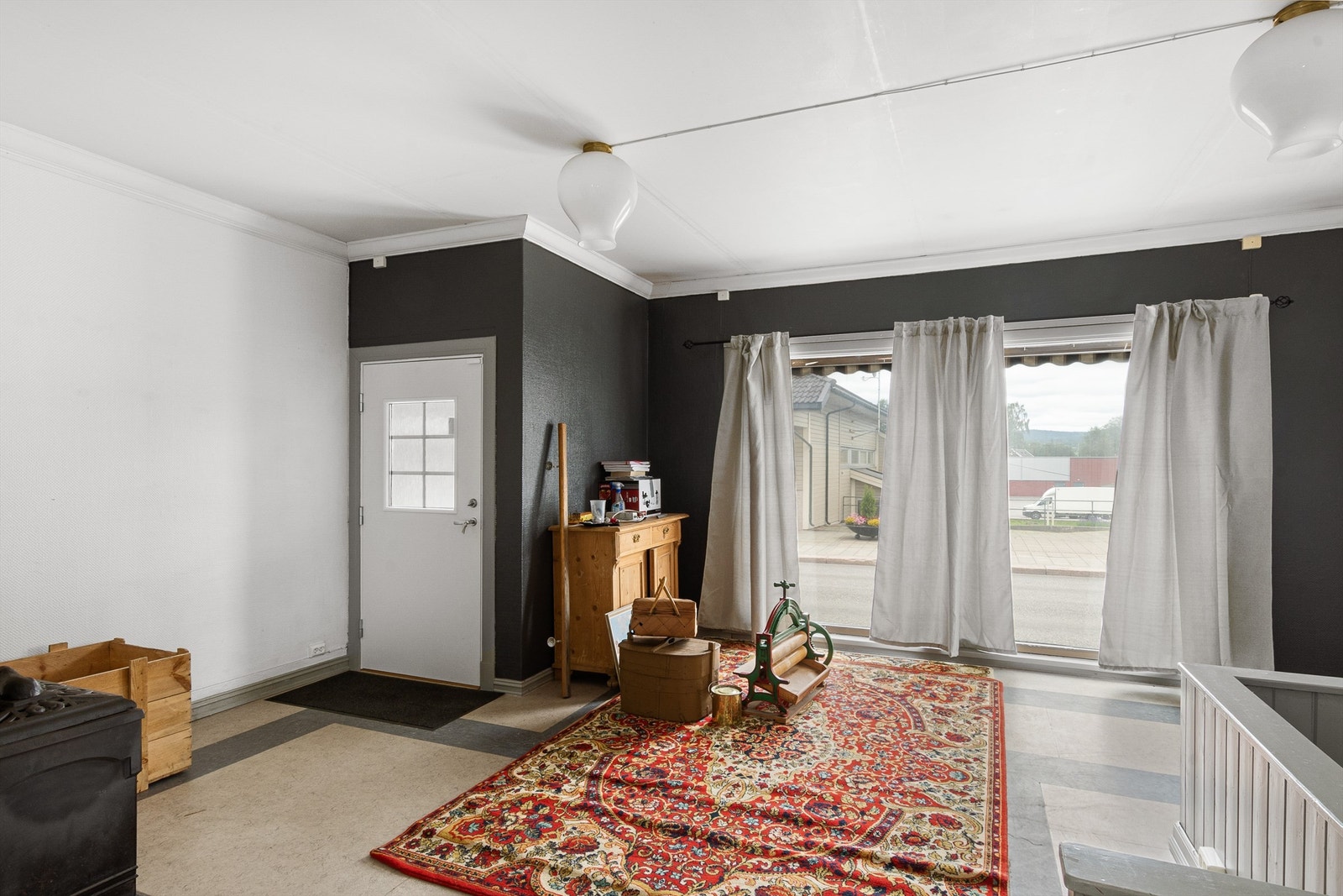 Åpen løsning videre inn til butikklokalene. Dette rommet har hvit og svartmalte vegger og grått belegg på gulvet. To store vinduer ut mot gaten slipper dagslyset inn og gir de ute god innsikt. Her er det etablert trapp ned til kjeller. Galleribilde