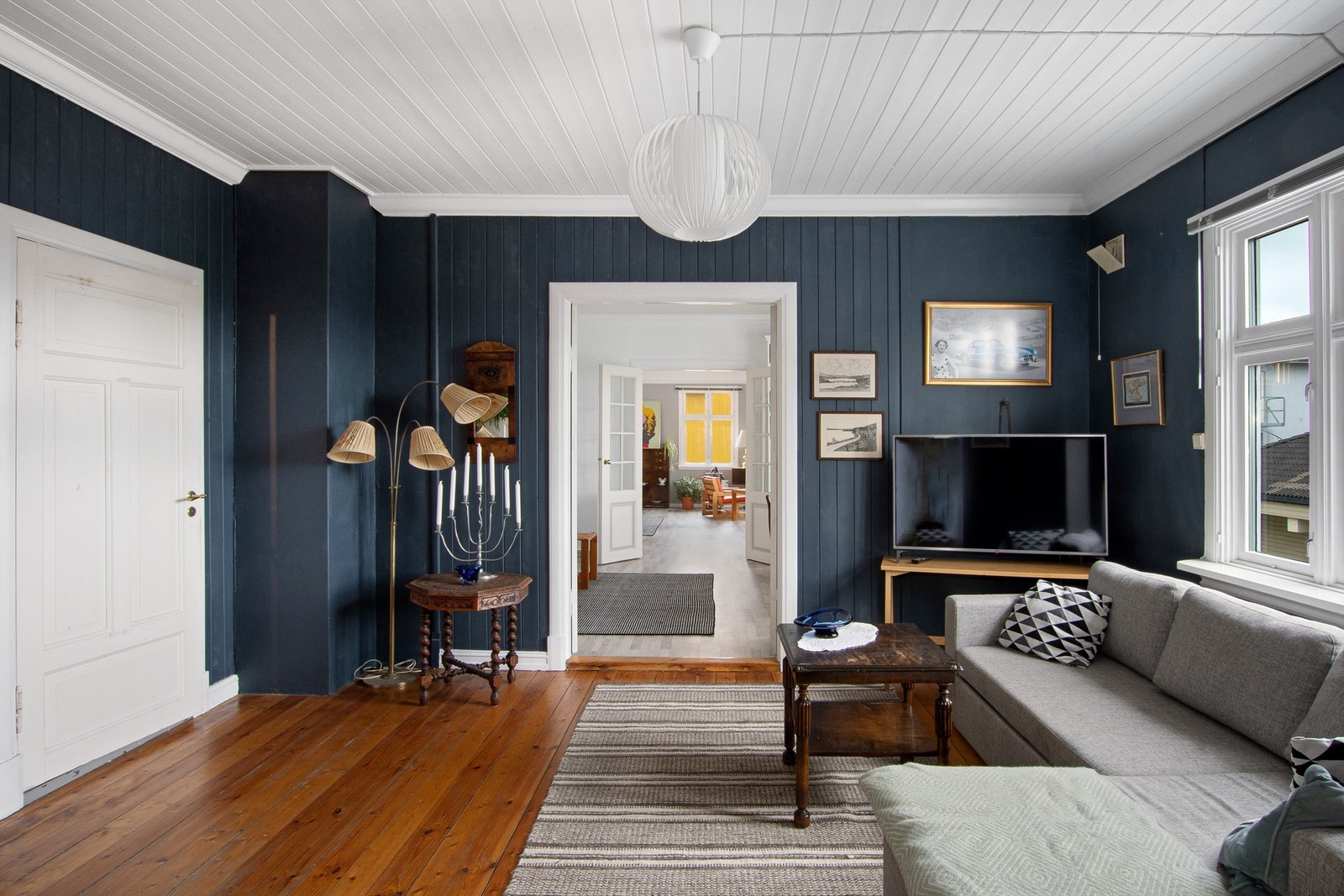 Peisestuen har mørkblå malt panel på veggene og tregulv. Rommet er lunt på sin måte med den blåfargen på veggene. Galleribilde