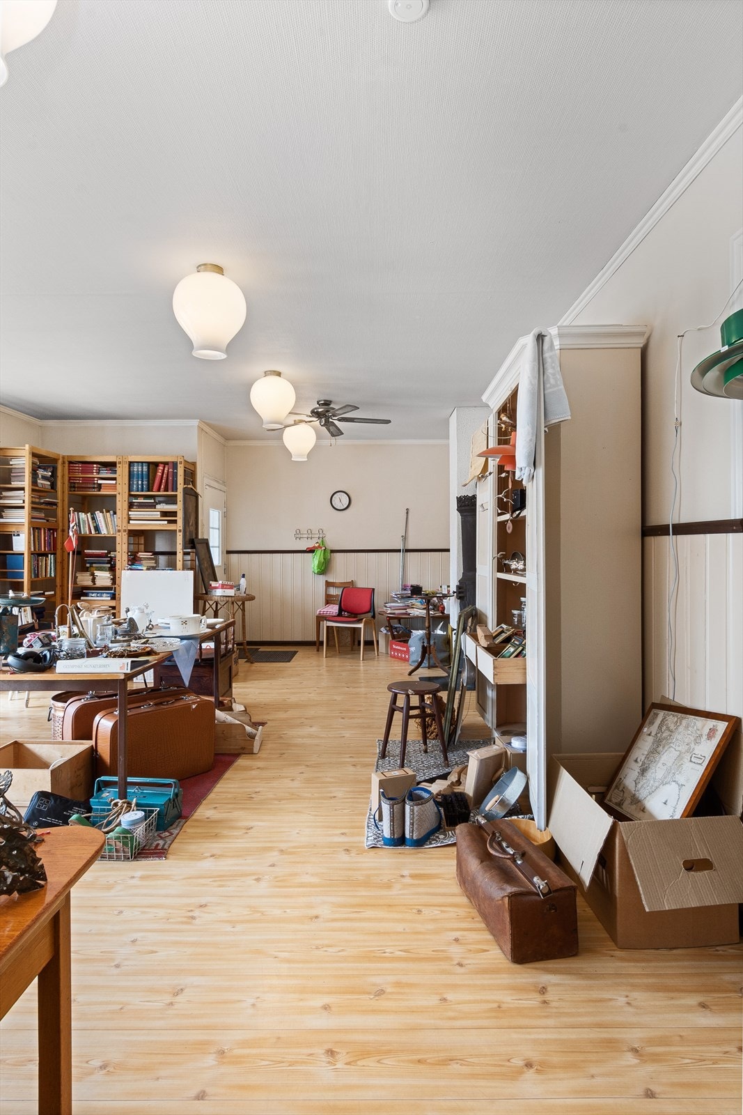 Videre inn til annet rom i butikken er det lyse fliser på gulvet og lyst brystningspanel på veggene og lysmalt strie. Galleribilde