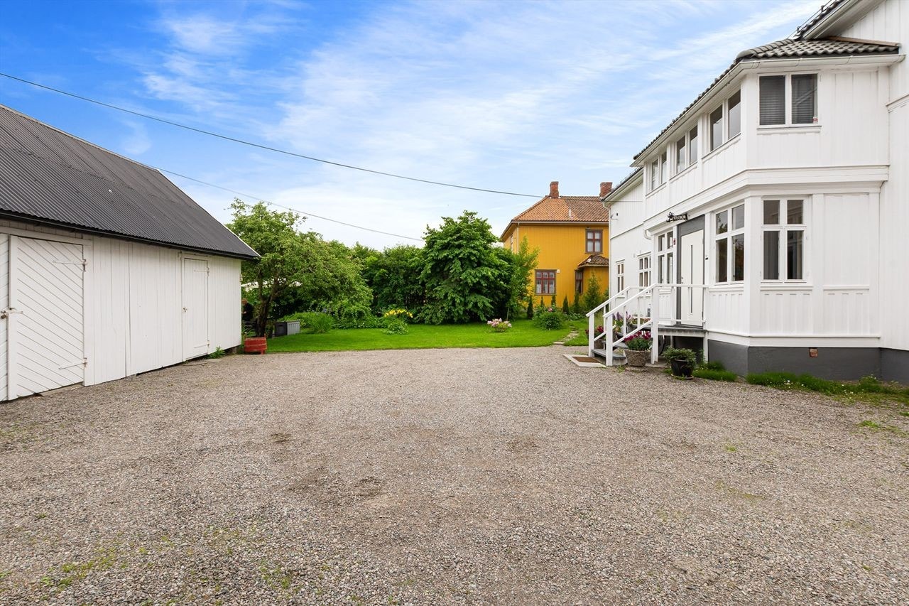 Gruset gårdsplass med gode parkeringsmuligheter og garasje/uthus. Galleribilde