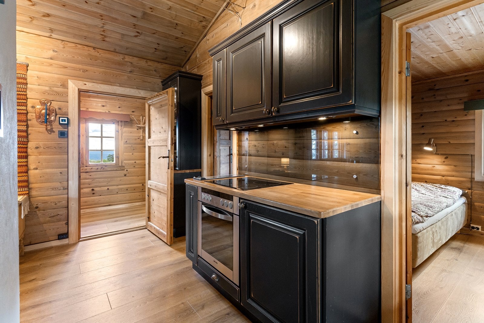 Bak døra ut mot gangen har man et flott høyskap i samme stil som øvrige deler av kjøkkenet, med integrert belysning og flotte vitrineskapsdører. Perfekt til oppbevaring av diverse glasstøy mv. Galleribilde