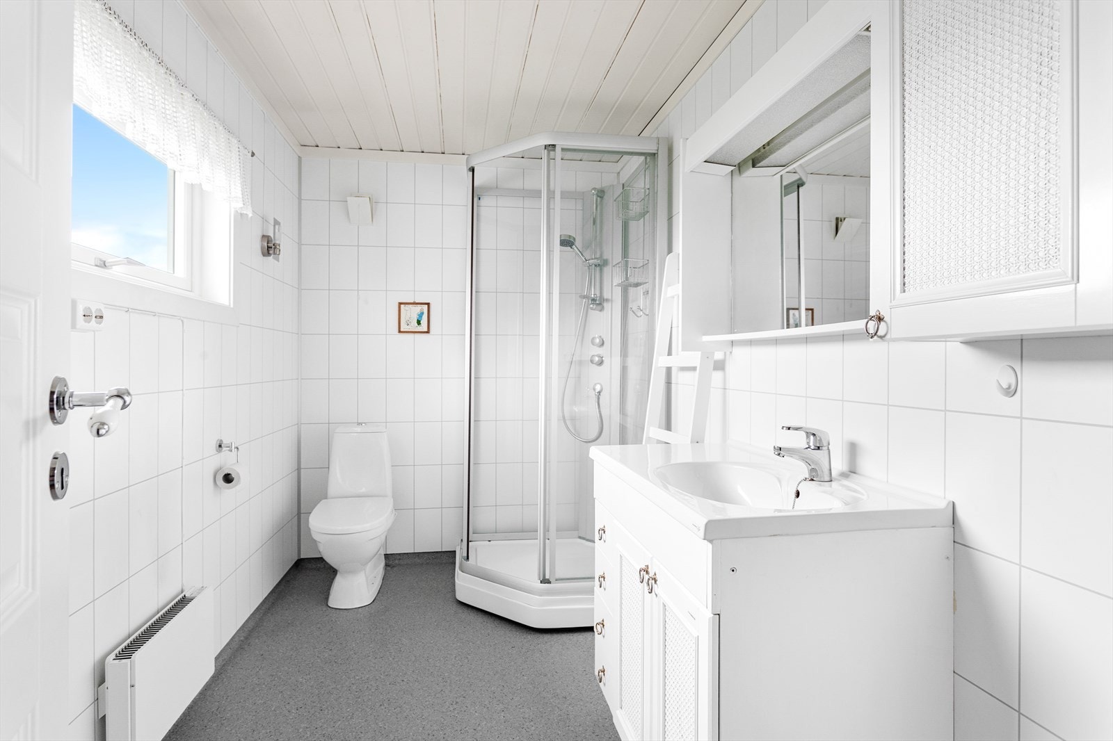 Innredningen består av gulvmontert wc, dusjkabinett og servant med over- og underskap, samt speil. Opplegg for vaskemaskin. Galleribilde