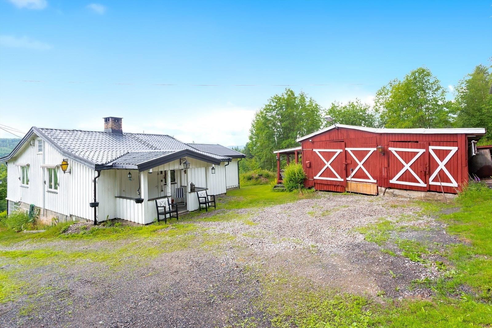 Grusbelagt gårdsplass foran boligen og uthuset. Galleribilde