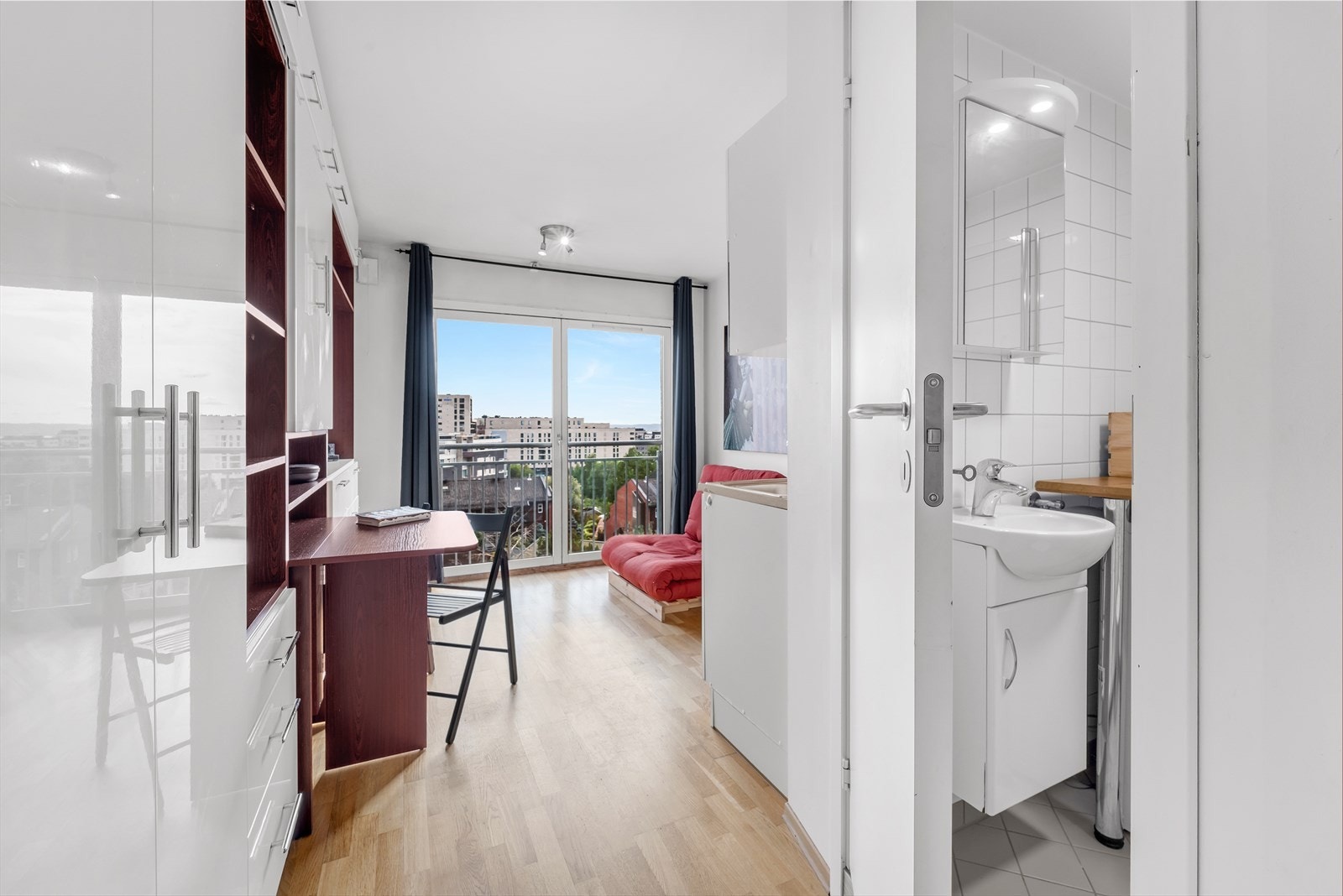 En lys og arealeffektiv 1-roms med fransk balkong beliggende høyt og fritt i 4. etasje med fantastisk utsikt over byen og fjorden Galleribilde