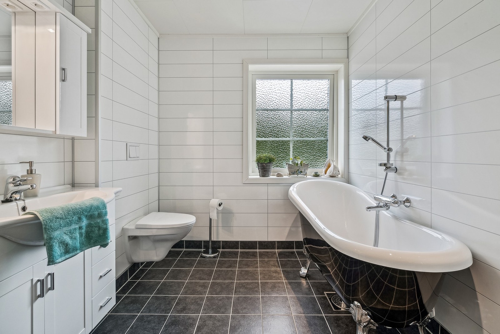 Rommet er utstyrt med dusjkabinett, servant, vegghendt toalett og ikke minst lekkert badekar Galleribilde