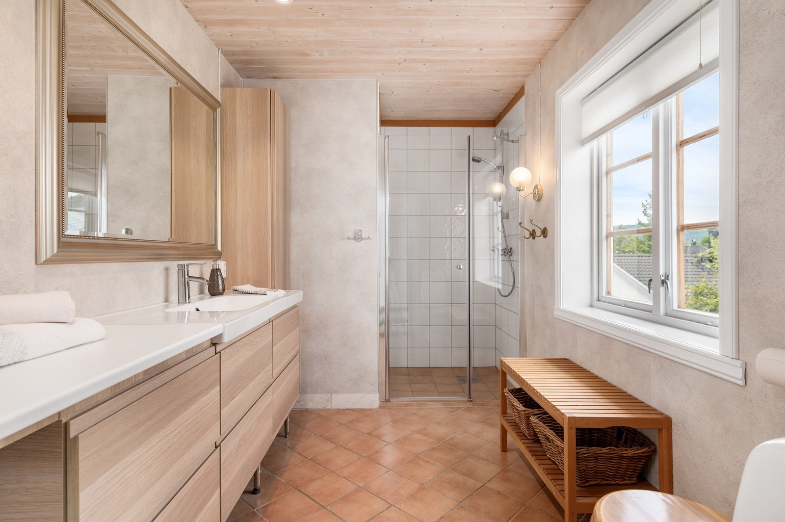 Meget pent og tidløst delvis flislagt bad på 5,5 kvm innredet med servantskap med speil og sideskap, toalett og dusjhjørne. Galleribilde