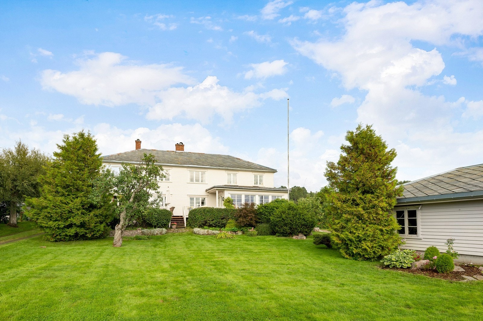 Variert beplantning på eiendommen, store trær og frukttrær. Galleribilde
