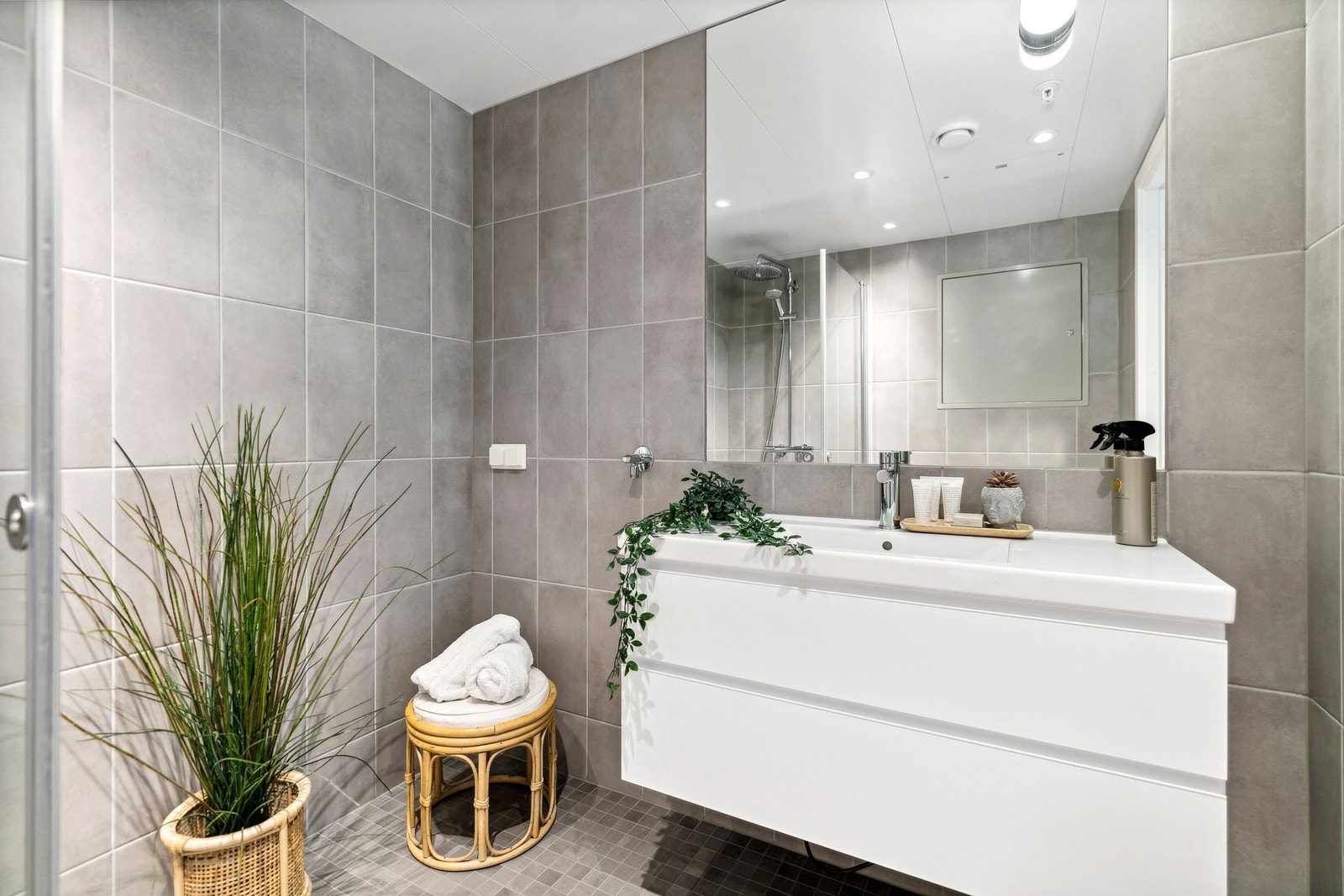 Badet i leiligheten er moderne og praktisk. Baderomsinnredningen består av servant med underskap og speil Galleribilde