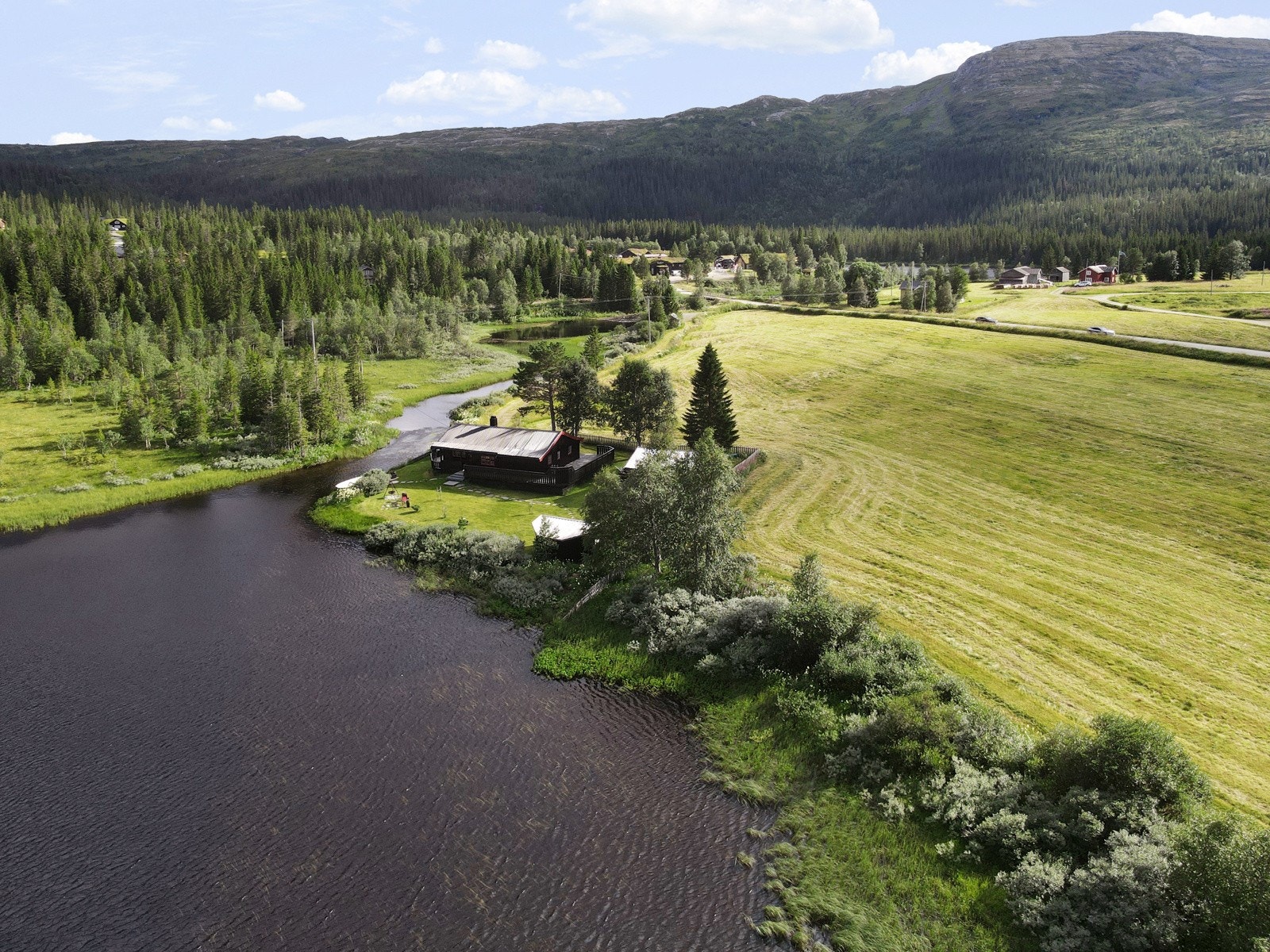 Oversikt over tomta med Teveltunet i bakgrunn. Galleribilde