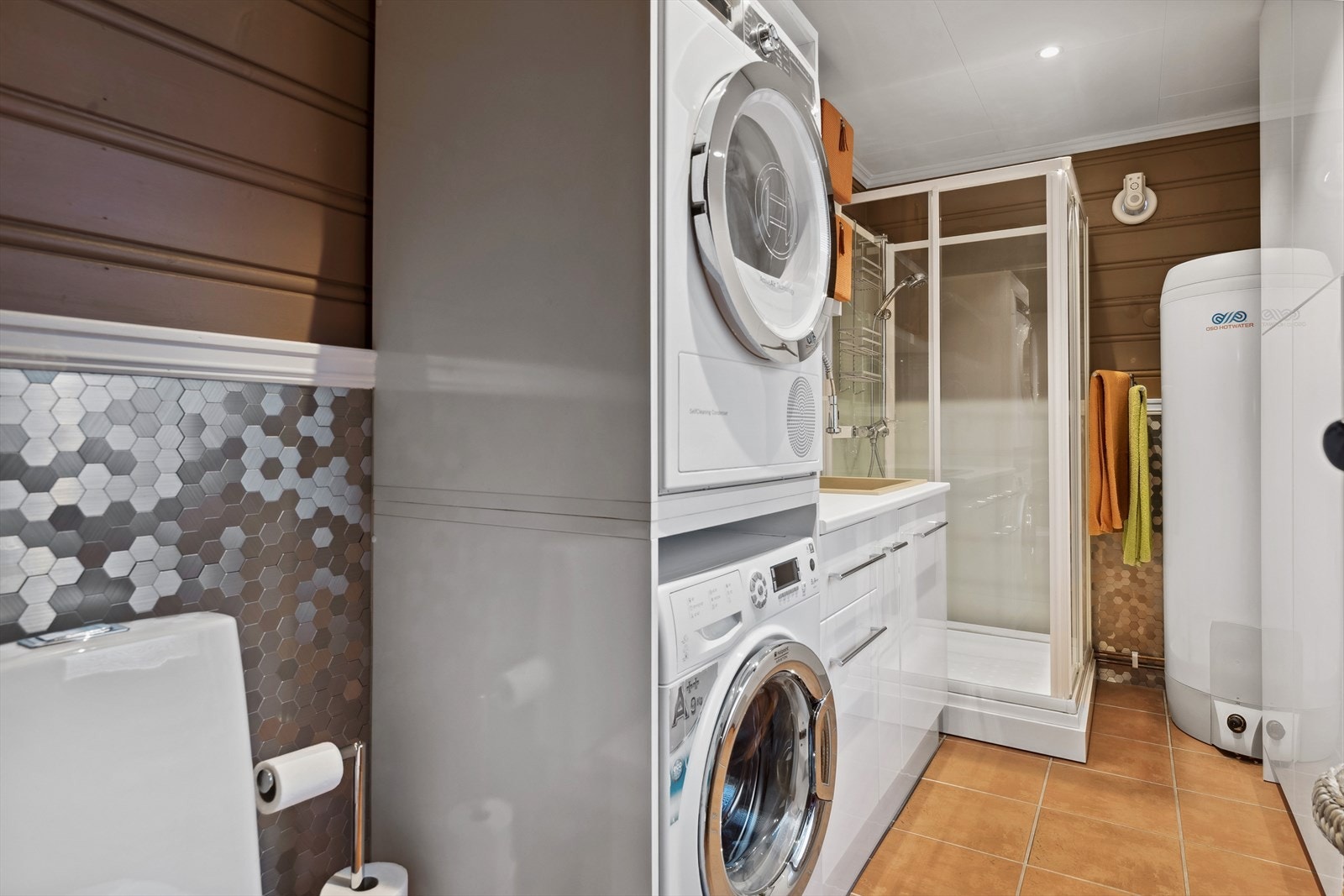 Vaskerommet har fliser på gulvet og panel samt fliser i børstet stål på veggene. Galleribilde